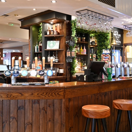 Interior bar area of a pub with stools.