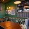 An image focusing on two of the tables within the interior restaurant seating area with tables, chairs, cushioned seating and Specials advertising chalkboard at The Spice Island.