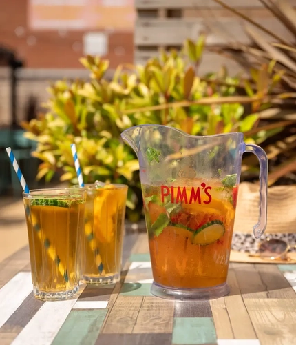 PL - A jug two glasses of Pimms on a table in a beer garden