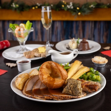 plates of food sitting on a wooden table of a pub