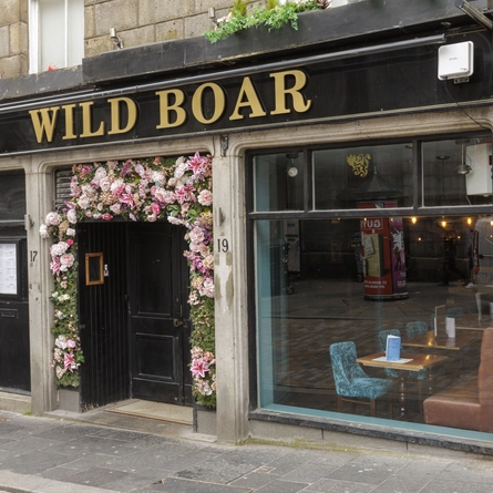 The exterior facade with floral entrance arch decor at The Wild Boar.