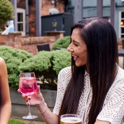 A mixed group of people enjoying cocktails in a beer garden.