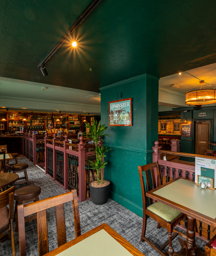 An interior restaurant seating area at The Junction in Upminster, with TVs on the walls.