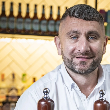 A man standing behind a bar.