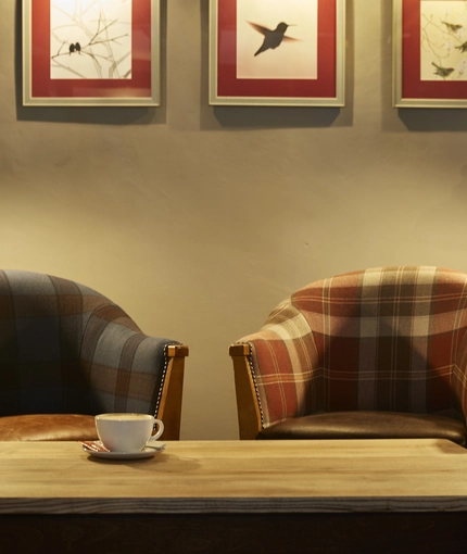 A table with arm chairs in a seating area of The White Hart.