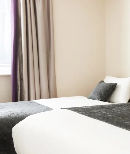 The interior of one of the hotels room featuring a double and a single bed at The Quays.