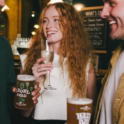 A lifestyle image of 3 friends stood enjoying various drinks within the interior of an Urban Core Venue.