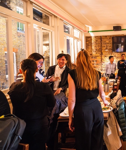 An image of customers stood within the interior restaurant seating area with the bar in the background enjoying drinks at The Kings Stores.