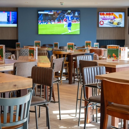 The interior restaurant and seating area with TV at the Woodlands Edge.