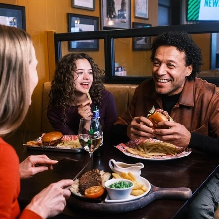 A family enjoying a meal and drinks in the interior restaurant from the new Spring/Summer menu at Flaming Grill.