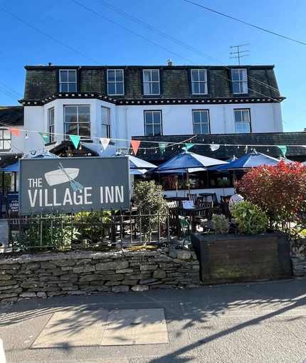 An image of the exterior facade with outdoor seating area at The Village Inn.
