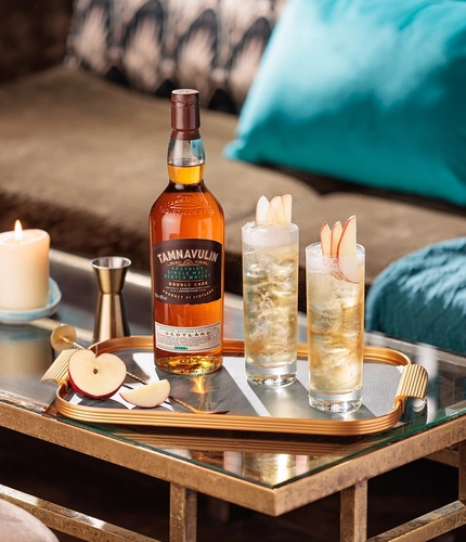 A tray on an indoor coffee table, with a bottle of Tamnavulin and a couple of glasses containing liquid.