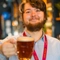 A team member holding up a pint of beer.