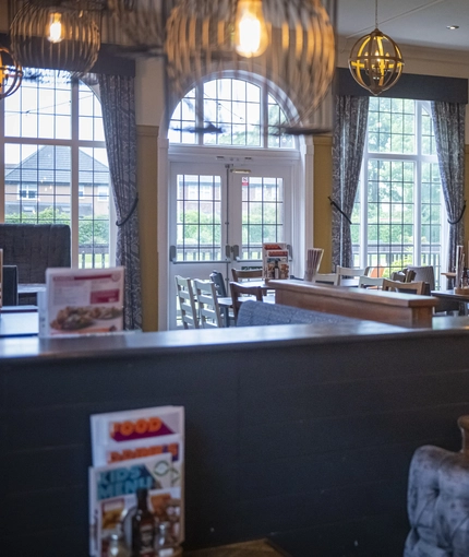 Interior dining area of a pub with a TV and a fireplace.