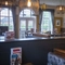 Interior dining area of a pub with a TV and a fireplace.