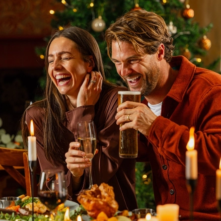 An image of 2 adults enjoying drinks with main dishes within the interior restaurant seating area at a Venture Hotel venue.