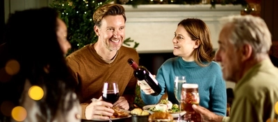 An image of 4 people sat around a table within the exterior restaurant and seating area enjoying various drinks and main dishes available at Chef & Brewer venues.