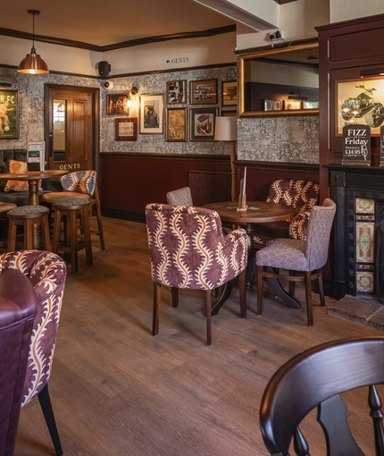 The interior restaurant seating area with feature fireplace at The Crown & Horseshoes.