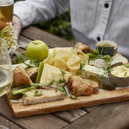 An exterior shot of people enjoying food served in a beer garden at a Chef & Brewer venue.