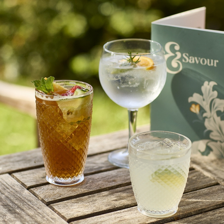 An exterior shot of a selection of drinks in a beer garden promoting 'Summer Serves' at Chef & Brewer venues.