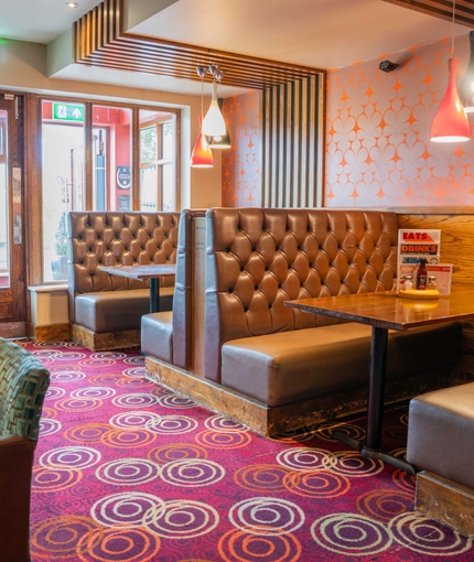 The interior restaurant seating area of The Royal Horse, with wooden tables and upholstered seating.