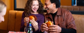 A family enjoying a meal and drinks in the interior restaurant from the new Spring/Summer menu at Flaming Grill.