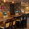An interior restaurant seating area at The Royal Oak; with an upholstered booth seat along one side of the room, and framed artwork on the floral wallpapered wall above it.