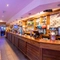 Interior bar area and dining area of a pub with a few gambling machines.