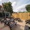 An image of the exterior beer garden seating area with partial covered section and outdoor TV at The Old Red Lion.