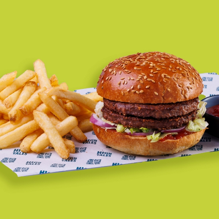 HighTales vegan stack burger served on a board.