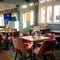 The interior restaurant seating area at the Green Posts in Portsmouth, with a TV on the wall, and upholstered seating.