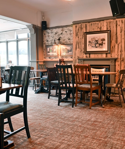 Interior dining area of a pub with a fireplace.