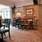 Interior dining area of a pub with a fireplace.