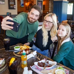 A family taking a selfie in the pub