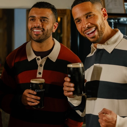 An image of 3 friends with pints of Guinness stood within the interior watching the Six Nations at The Crown.