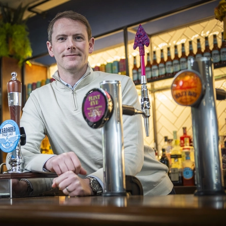 A man standing behind a bar.