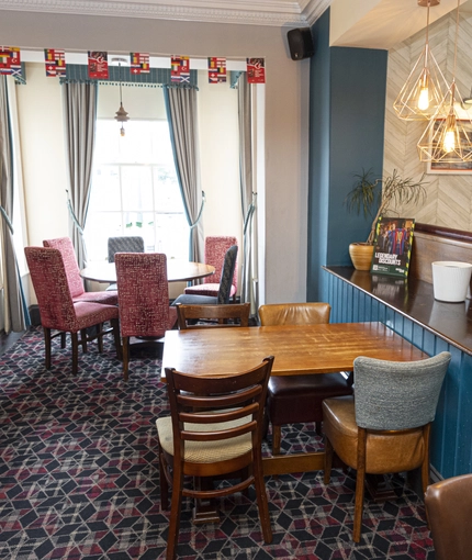 Interior dining area of a pub with a TV.