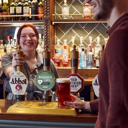 A person serving drinks at the bar