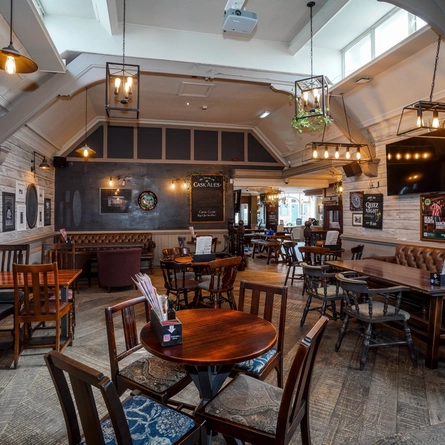 Interior dining area of a pub with a TV.