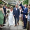 A bride and groom walking through an archway of guests.