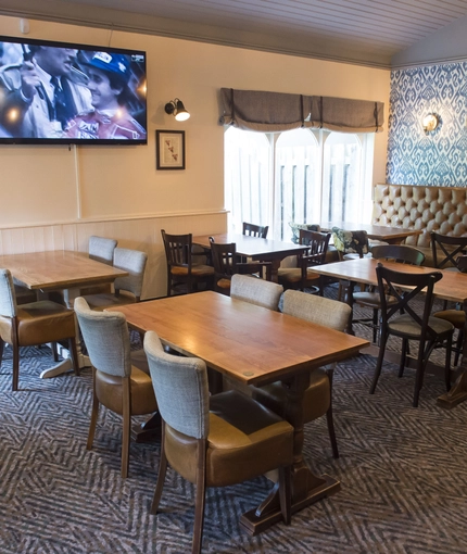 Interior dining area of a pub with a TV.