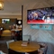 The interior restaurant seating area at The Steam Turbine, with TVs on the walls, and a dartboard.