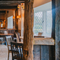 The interior restaurant seating area at The Green Man, with wooden beams on the walls and ceiling, and a fireplace.