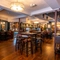 The bar and interior restaurant seating area at the Lord Raglan in Holborn, with a TV on the wall, and a staircase leading to the upper floor.