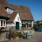 The exterior facade, seating area, and disability-friendly main entrance of the Rudds Arms; with an accessibility ramp leading up to the door.