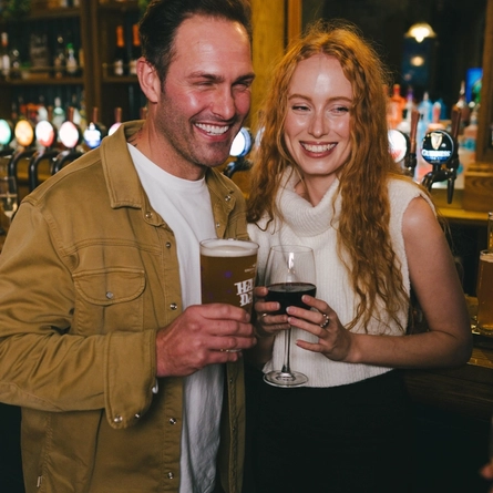A lifestyle image of 2 friends stood at the bar enjoying various drinks within the interior of an Urban Core Venue.