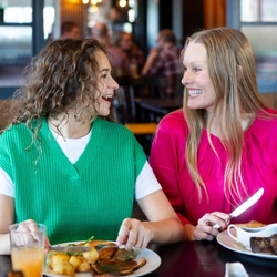 A family enjoying a meal and drinks in the interior restaurant from the new Spring/Summer menu at Flaming Grill.