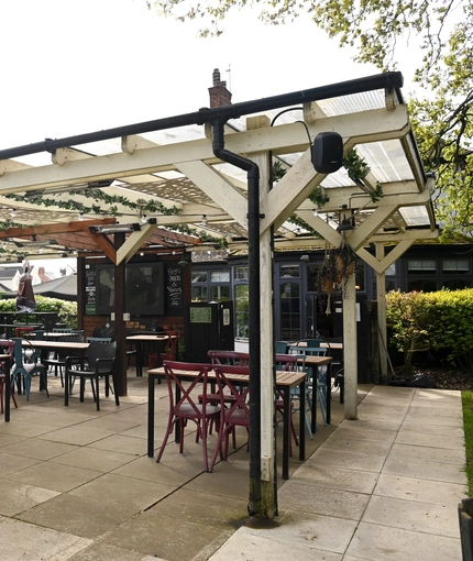 Exterior beer garden of a pub with a gazebo, a seating area and a TV.