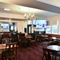 interior dining area of a pub with a TV and a dartboard