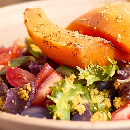Close-up of a fresh summer salad with roasted vegetables and leafy greens available at Chef and Brewer venues.